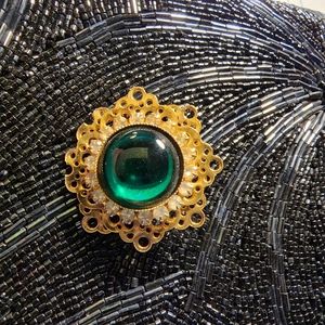 A Gold Filigree Base on top is a gorgeous Green Shiny Green Stone.